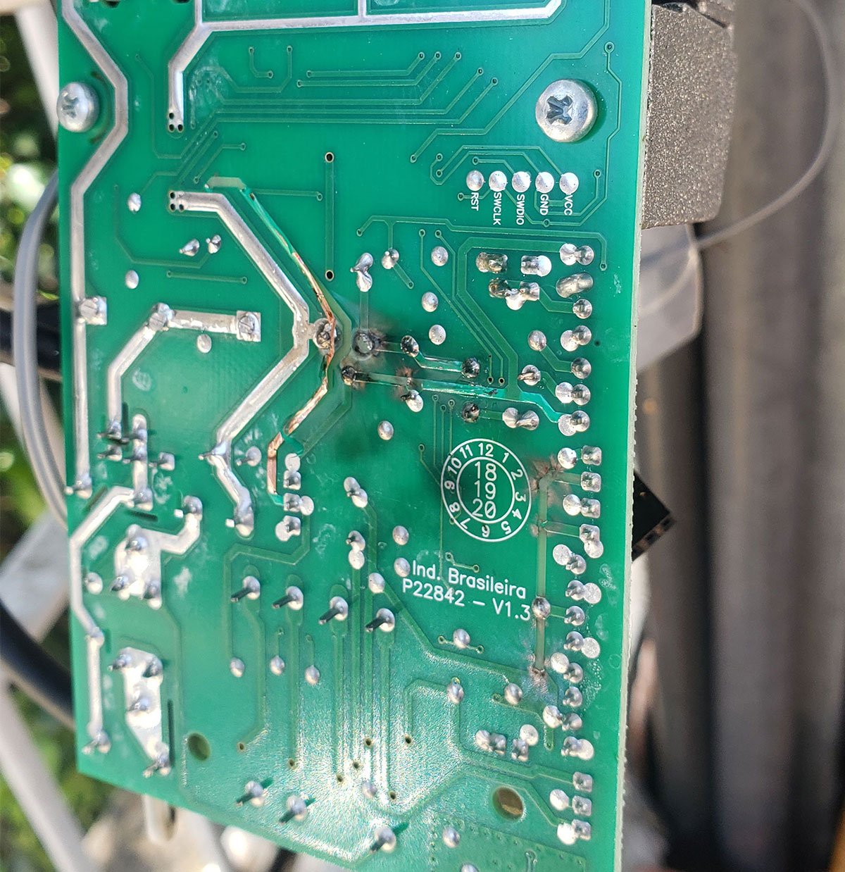 Chamuscamento em central de portão automático causado por descarga elétrica — dano visível na placa