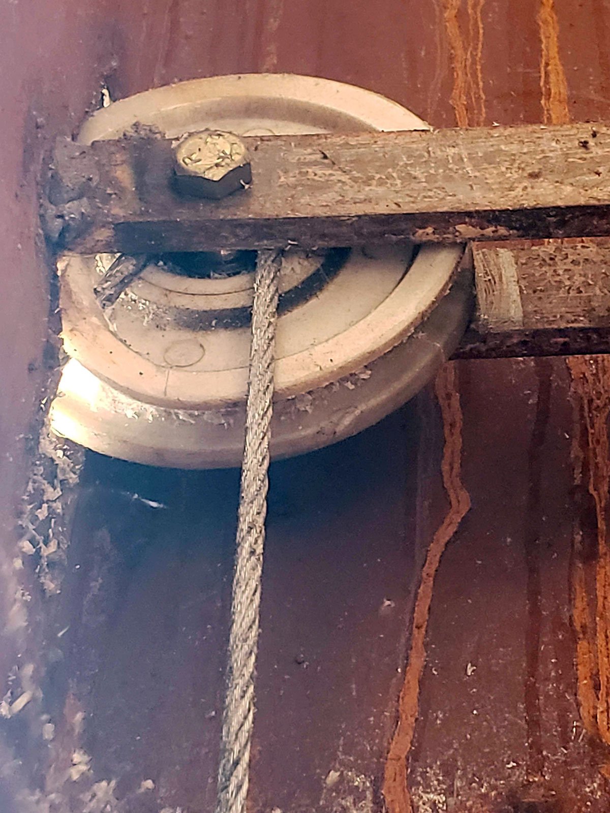 Roldana de fibra inadequada para portão basculante com desgaste prematuro — substituição por material correto